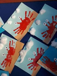 four handprints with red and white paint on them are arranged in the shape of clouds