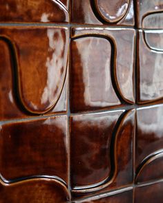 a close up view of a wall made out of brown tiles with wavy lines on it