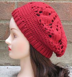 a female mannequin head wearing a red knitted hat with holes on it