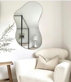 a living room with a chair and mirror on the wall