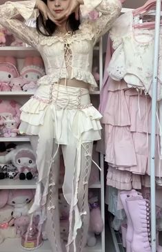 a woman standing in front of a closet filled with pink and white clothes, holding her hands on her head