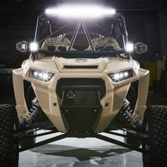 an off - road vehicle is parked in a garage with lights on it's headlamps