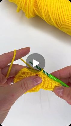 someone crocheting the end of a piece of yellow yarn