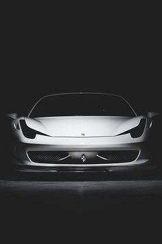 a white sports car is shown in the dark