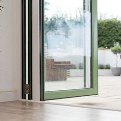 an open sliding glass door on the outside of a house with potted plants in the background