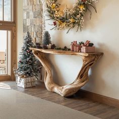 a wooden table sitting next to a christmas tree in front of a wall mounted wreath