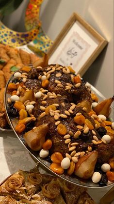 an assortment of desserts and pastries displayed on serving platters at a party