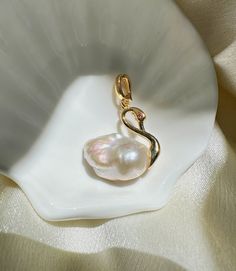 Capture the grace of a swan with our Gold / Silver Swan Pearl Necklace, a symbol of purity and refinement. This stunning piece features a lustrous natural pearl gracefully set in a golden swan design, perfect for elevating any outfit from ordinary to extraordinary. Comes with necklace chain. Available in regular or premium quality pearls. Measurements: Pearl Size:  around 14*20mm  (0.55'' * 0.78'') Pendant Size: around 23*25mm  (0.9'' * 1'') Necklace Length: 40cm  (15.7 '') Materials: AAA+ Fresh Swan Jewelry, Swan Pendant, Swan Design, Gold Swan, Swan Necklace, Schmuck Gold, Silver Swan, Natural Pearl Necklace, Gold Pearl Necklace