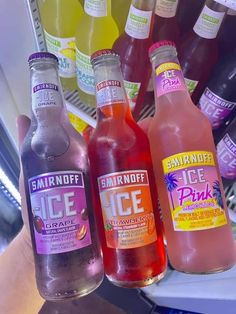 three bottles of different flavored beverages on display