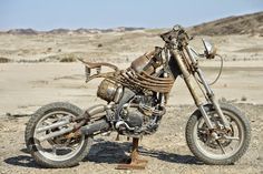 an old motorcycle is sitting in the desert