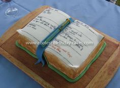 an open book cake on top of a wooden cutting board