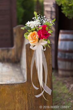 a bouquet of flowers sitting on top of a wooden bench