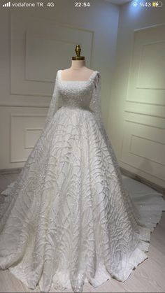 a white wedding dress on display in a room