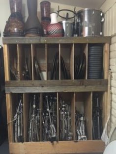 a wooden shelf filled with lots of black and white dishes