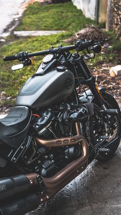 the motorcycle is parked on the side of the road in front of some grass and trees