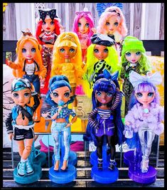 a group of dolls that are standing next to each other in front of a fence