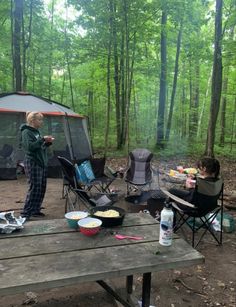 two people sitting at a picnic table in the woods