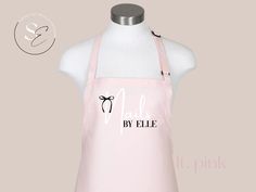 a pink apron with the words nails by ellie on it and a bow at the front