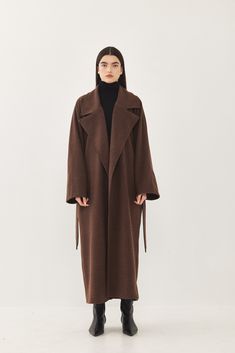 A heavy weight longline rode coat. An oversize fit with long voluminous sleeves and side pockets. Features a lapel collar with an embroidered logo. Comes with a detachable waist belt. A cozy worm coat you can wear over any outfit. 100% Polyester Color: Brown Care: Dry clean only Oversize fit, take your usual size. Model wears: M Model's fit:1.75 cm Waist 59 cm Hips 86 cm Bust 78 cm How to measure yourself Oversized Winter Coat, Long Wool Coat Women, Brown Wool Coat, Voluminous Sleeves, Longline Coat, Wool Coat Women, Long Wool Coat, Long Trench Coat, Suede Coat