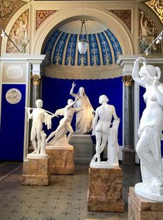 several statues in a room with blue walls