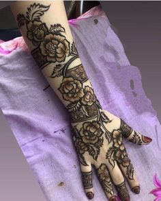 a woman's hand with henna tattoos on it