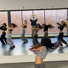 a group of people that are standing up in the middle of a dance studio together