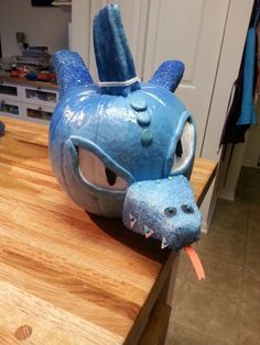 a blue dragon mask sitting on top of a wooden counter