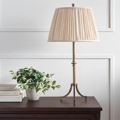 a lamp that is sitting on top of a table next to a potted plant