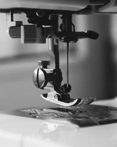 the sewing machine is being used to sew on clothes and other items in black and white