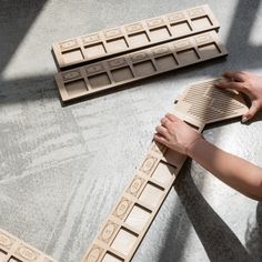 a person is working on some kind of wooden object with numbers and letters carved into it