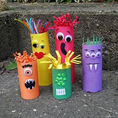 four different colored paper tubes with faces on them