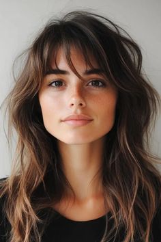 Woman with long, wavy brown hair and bangs, wearing a black top, looking confidently at the camera. Butterfly Haircut Bangs, Statement Haircut, Butterfly Haircut With Bangs, Haircut Ideas For Girls, Butterfly Bangs, Haircut For Long Hair, Butterfly Layers, The Butterfly Haircut, Butterfly Haircut