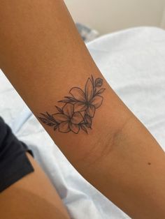 a woman's arm with a flower tattoo on the left side of her arm