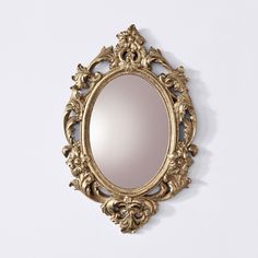 an ornate gold framed mirror on a white wall