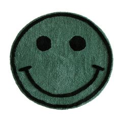 a green rug with a smiley face on it's center and two black dots in the middle