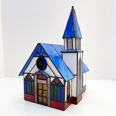 a small stained glass church with a clock on it's side and steeple