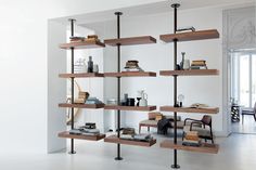 a bookshelf filled with lots of books on top of wooden shelves in a room