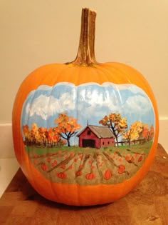 a painted pumpkin sitting on top of a wooden table