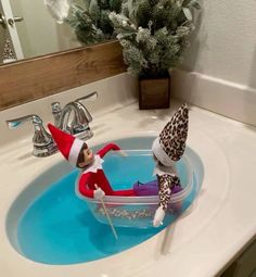 an elf is sitting in the bathroom sink