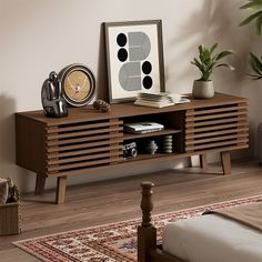 a bed room with a neatly made bed and a wooden sideboard next to it