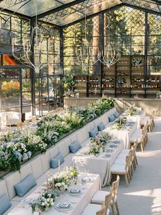 an indoor dining area with long tables and white tablecloths set up for a formal function