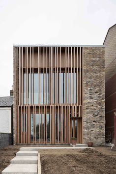 a brick building with wooden slats on the front and stairs leading up to it