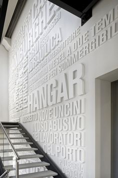 the stairs are made out of white letters and black handrails in front of a wall that reads hanggarr