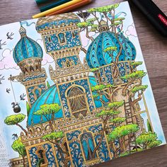 a drawing of a building with blue domes and trees on the outside, surrounded by colored pencils