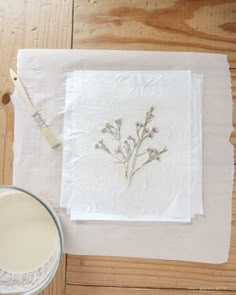 a table topped with a white plate and painting supplies next to a bowl of paint