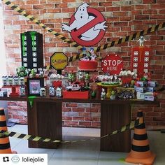 a table topped with lots of candy and candies next to a wall covered in signs