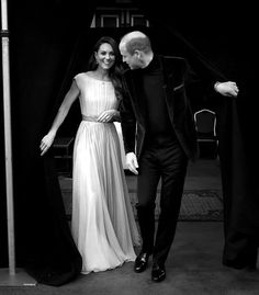 a man and woman in formal wear standing next to each other