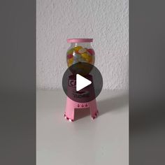 a candy dispenser sitting on top of a table next to a wall