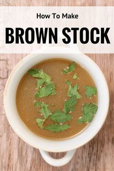 a white bowl filled with brown stock on top of a wooden table