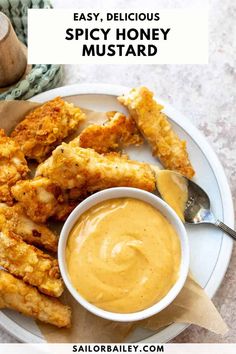 chicken wings and dipping sauce on a plate with the words easy, delicious spicy honey mustard